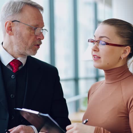 mature businessman and secretary argue indoors. young woman proves something to her boss and he denies. business concept.