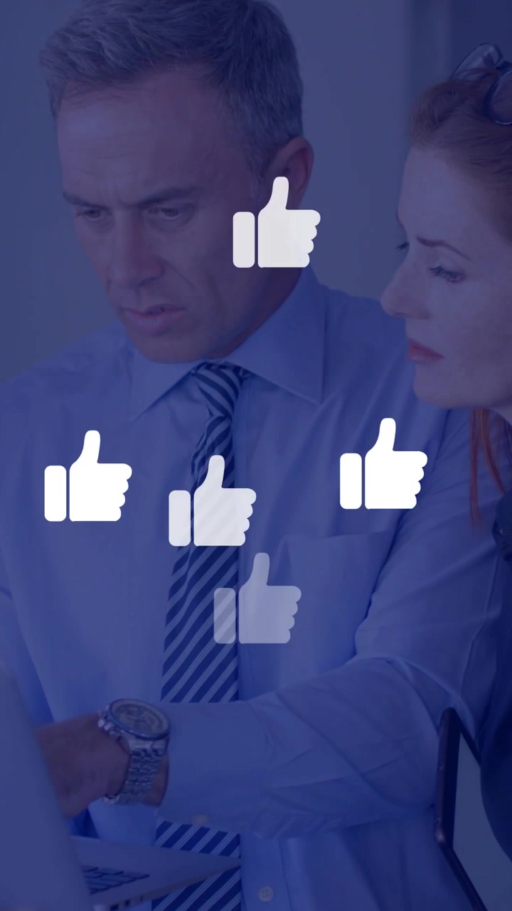 Vertical video: Two staff over laptop, man pointing, causing floating likes showing office approval