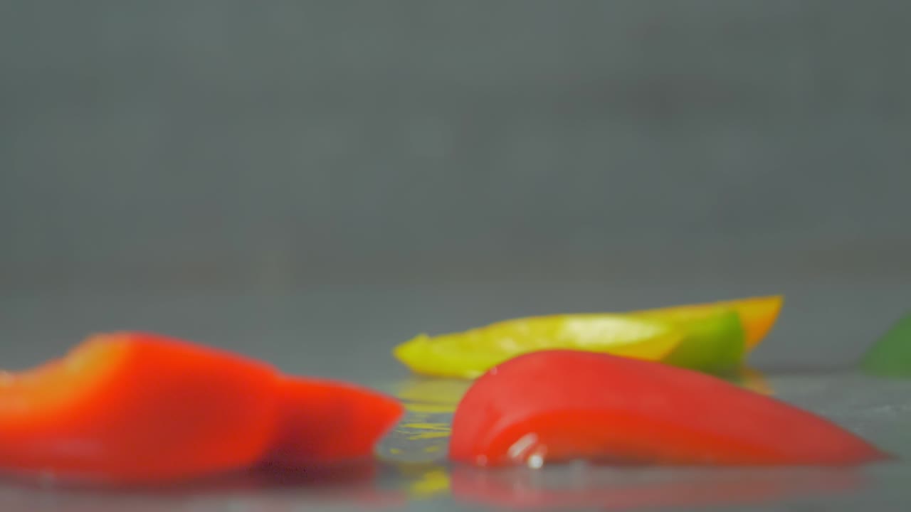 떨어지는 고추의 신선하고 여러 가지 빛깔의 조각, 물이 튀는, 클로즈업