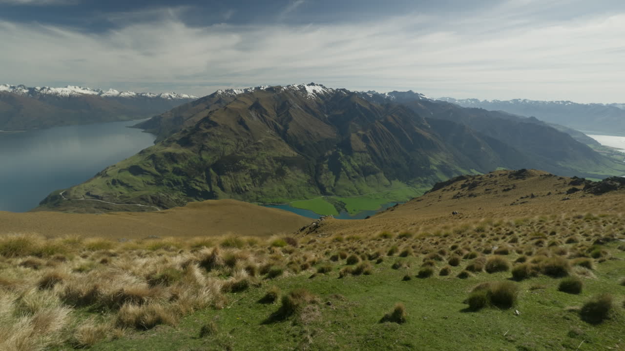vista a la montaña con pendiente herbosa en el pico del istmo en nueva zelanda, alpes del sur