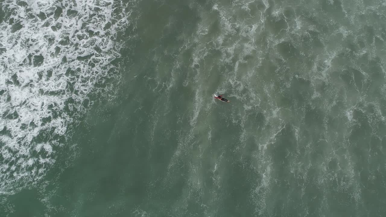 punto de vista cenital de surfista remando a través de la ola