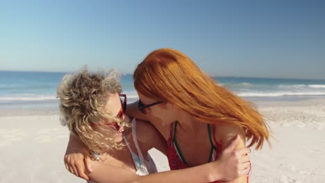 jóvenes amigas adultas divirtiéndose en la playa 4k