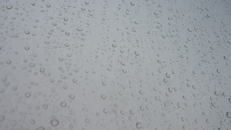 close-up view of a rainy glass as rain drops hits a window during a gloomy and overcast weather