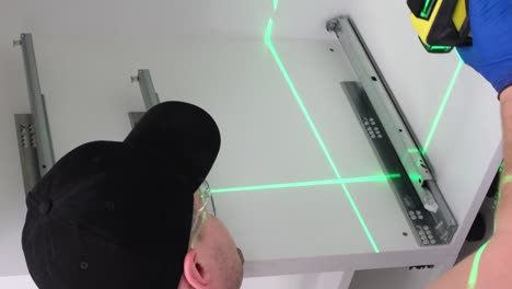 a man collects kitchen furniture repair of the kitchen using a construction laser