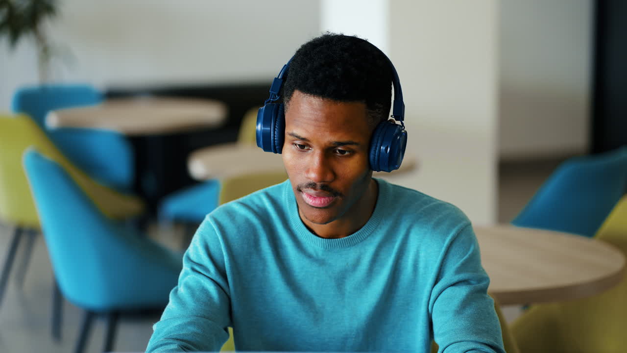 Young African American Man Working on Laptop with Headphones