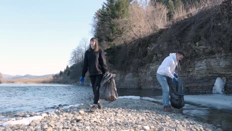 teamwork cleaning plastic on the beach. volunteers collect trash in a trash bag. plastic pollution and environmental problem concept. voluntary cleaning of nature from plastic. greening the planet