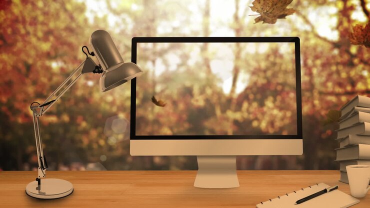 Animation of leaves falling over laptop and computer and desk