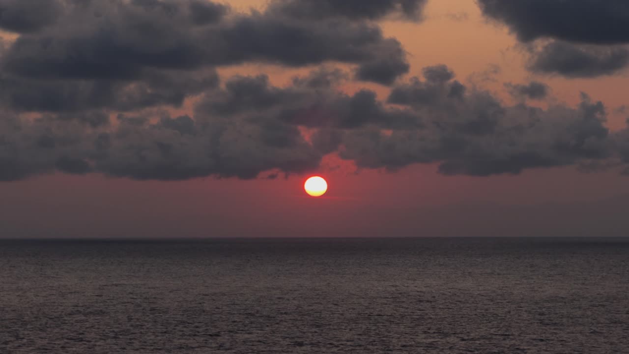 En fantastisk udsigt over solnedgangen over havet med en mørk, tæt, skyet himmel i Salento, Apulien, Italien – Panorering opad