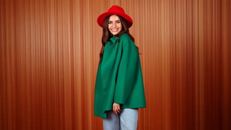 woman in green coat and red hat posing