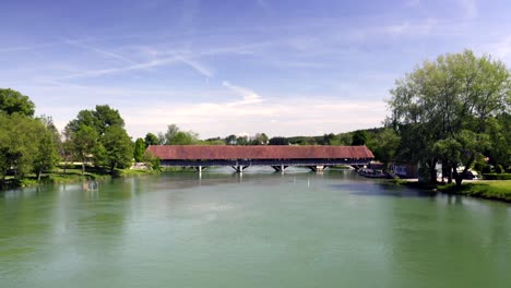 flight with the drone via the aare towards wangen an der aare swiss town in the canton of berne with a historic wooden bridge over the aare from the 14th century