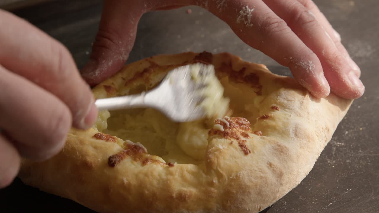 comiendo fresco y sabroso adjaruli khachapuri, primer plano en las manos