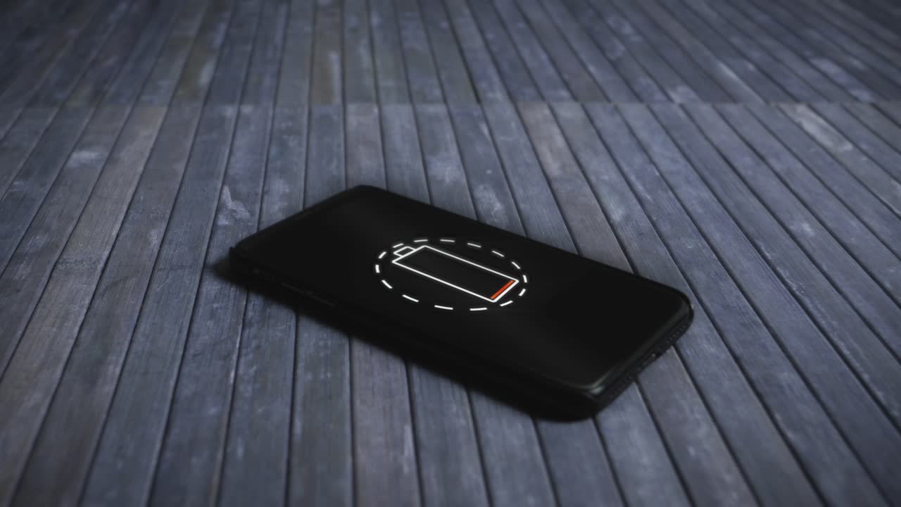 빈 배터리가 있는 비즈니스 스마트폰이 나무 바닥에 놓여 있습니다.