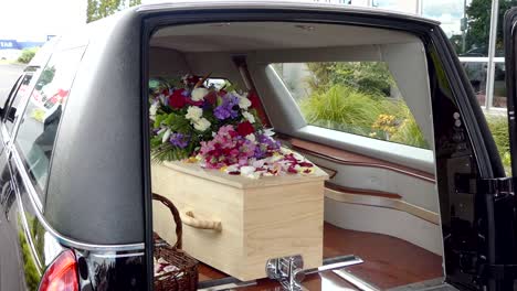 closeup shot of a funeral casket in a hearse or chapel or burial at cemetery