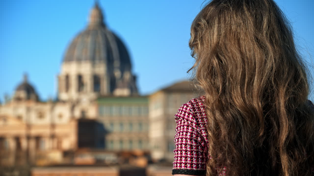 Blonde young woman in sunglasses smiles with Vatican city in background. Saint Peter's Basilica at sunset. Rome, Italy