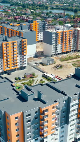 high-rise apartment buildings in the countryside. new complex of modern apartment buildings near the river. multi-storey housing. aerial view. rising up. vertical video