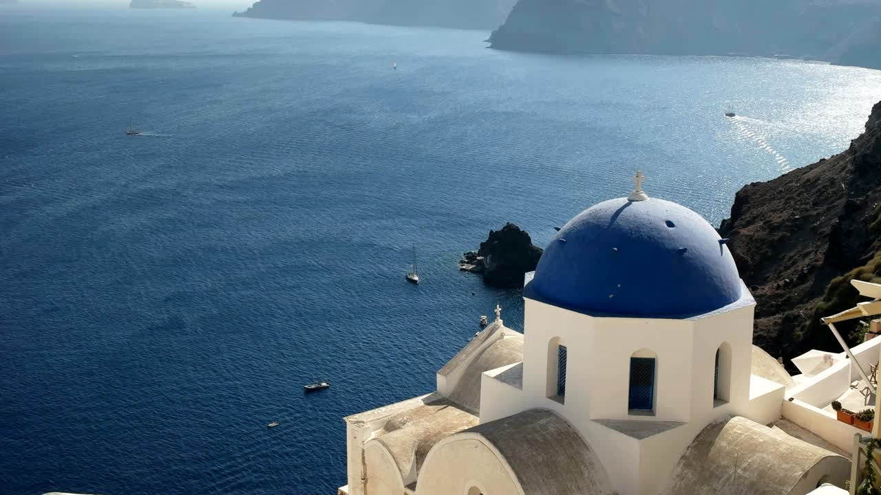 el ángulo alto de una iglesia con cúpula azul en oia, santorini