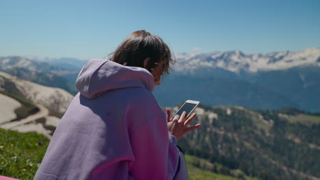 mujer usando teléfono en las montañas
