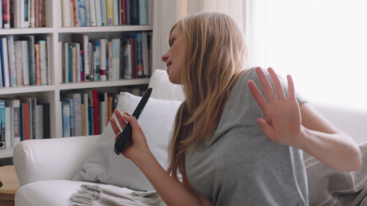 счастливая женщина поет караоке дома, веселится, танцует под музыку, празднует успех, наслаждается смешным танцем, чувствует себя положительно, стиль жизни, достижения, 4k-запись