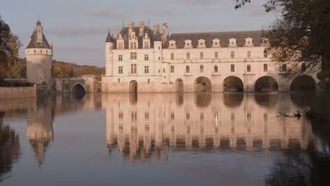 château de chenonceau reflected on the calm cher river in a serene autumnal landscape