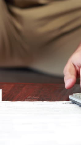 hombre ocasional molesto usando calculadora pagando facturas