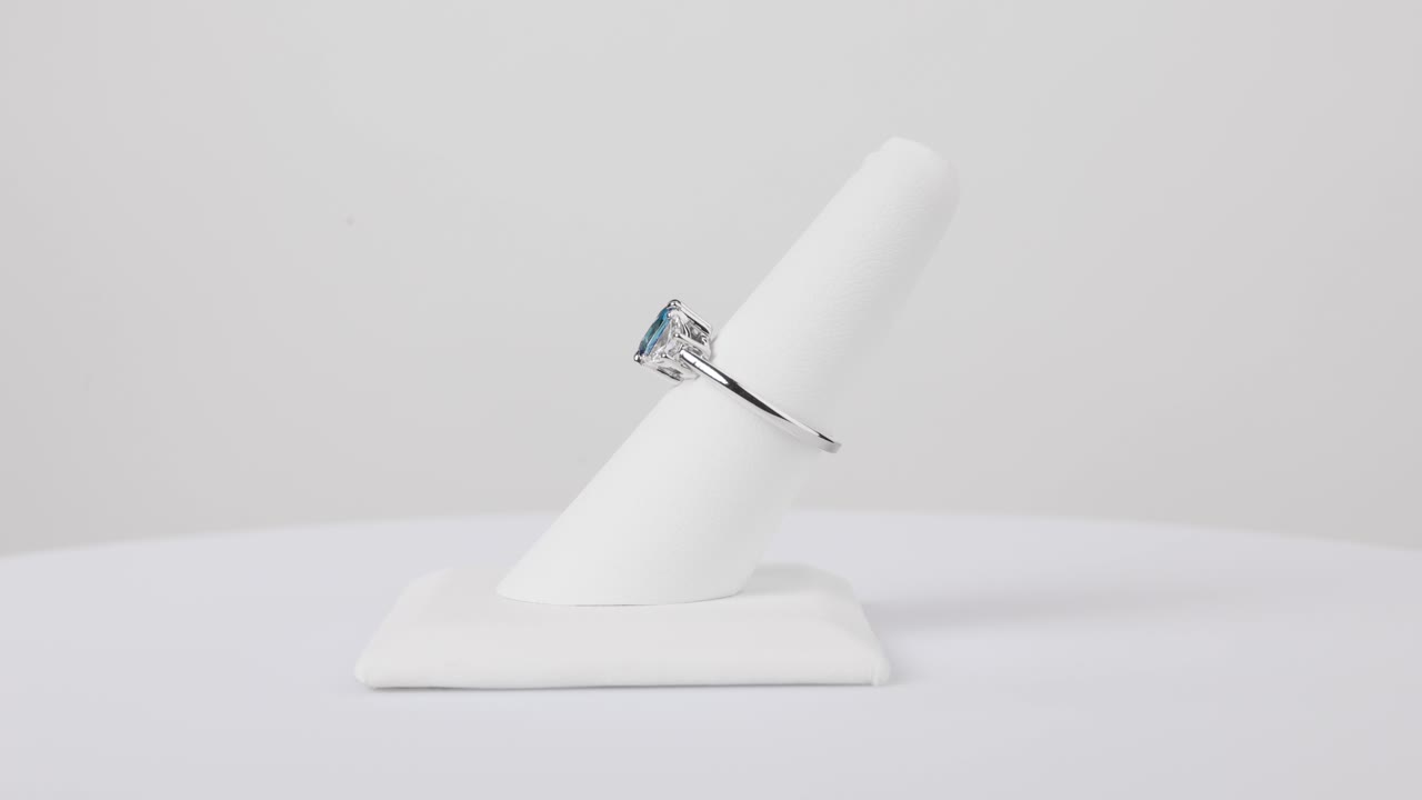 Elegant sapphire ring spinning slowly on a jewelry stand against a clean white background