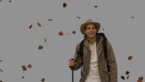 cheerful man standing under leaves falling on grey screen