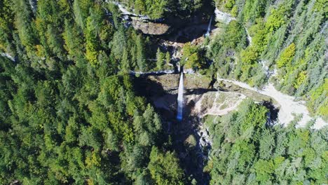 Vogelperspektive-Auf-Einen-Isolierten-Wasserfall,-Der-Vertikal-Von-Steilen-Felswänden-Inmitten-Dichter,-Dichter-Wälder-Fließt