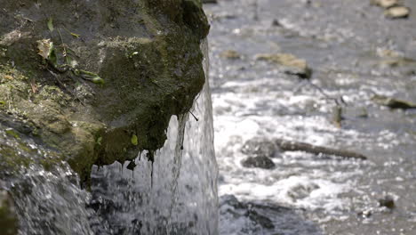 Mossy-rock-with-a-waterfall-running-over-it