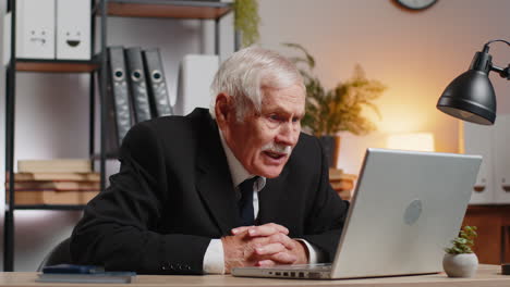 angry senior freelancer businessman in suit making webcam laptop online video call at home office