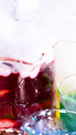 beakers with colorful liquids and rising smoke