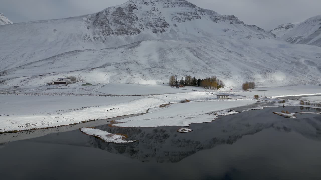 hermoso reflejo de montaña nevada en el lago en el impresionante paisaje de islandia, antena estableciendo inclinación hacia arriba