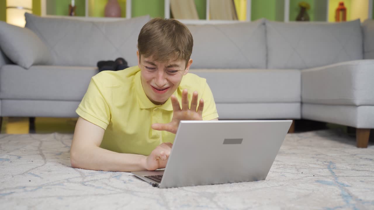 el joven está decepcionado en casa en la computadora portátil.