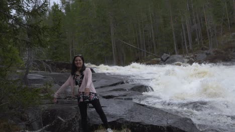 Happy-girl-playing-by-a-waterfall.-Slowmotion