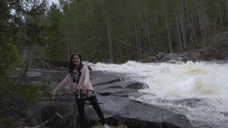 happy girl playing by a waterfall. slowmotion