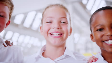 handheld panning shot of smiling schoolchildren, close up