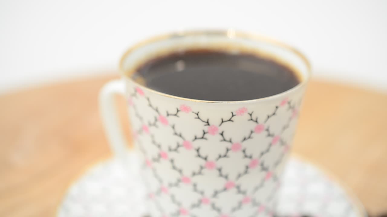Primo piano di caffè, tazza di caffè e chicchi. Ripresa in movimento.