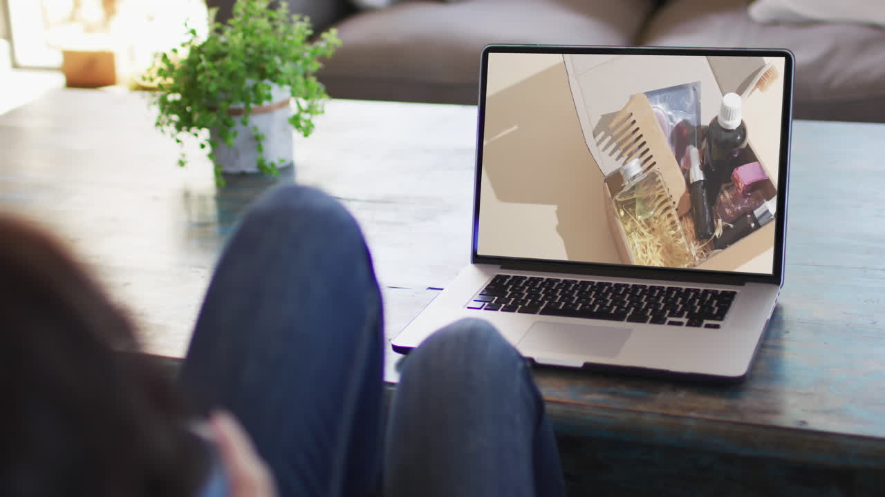 Knees of woman at table using laptop, online shopping for beauty products, slow motion