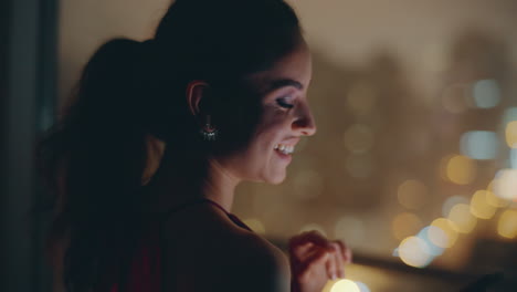 la silueta de la dama mirando por la ventana usando el teléfono inteligente en el paisaje urbano nocturno plano de primer plano