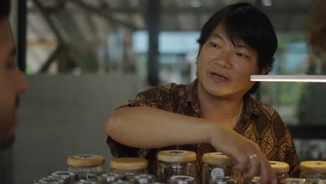 man explaining products in jars to a customer