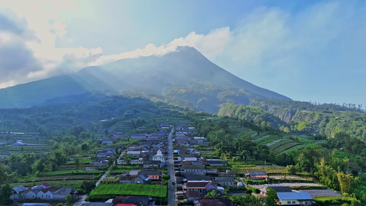 Aerial view of beautiful tropical rural landscape with mountain and God light. Sunlit village. Ray of light. Stabelan Village slope of Merapi Volcano, Indonesia.