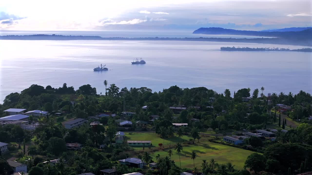 Wewak Hill Port fish container ship cargo vessels boat Dogreto Bay aerial drone East Sepik Region Province Papua New Guinea summer morning sunrise dry season clear skies forward pan up motion