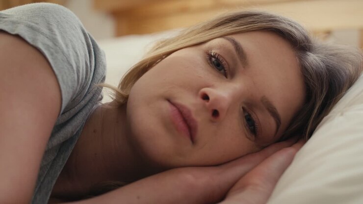 Donna caucasica triste sdraiata a letto.