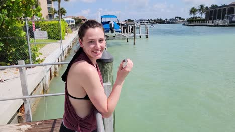 una mujer feliz sosteniendo un pez pargo de manglar se resbaló de la mano y cayó al agua mientras miraba la cámara
