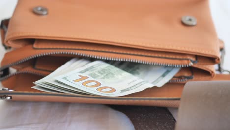 a close-up of a brown leather wallet with money inside