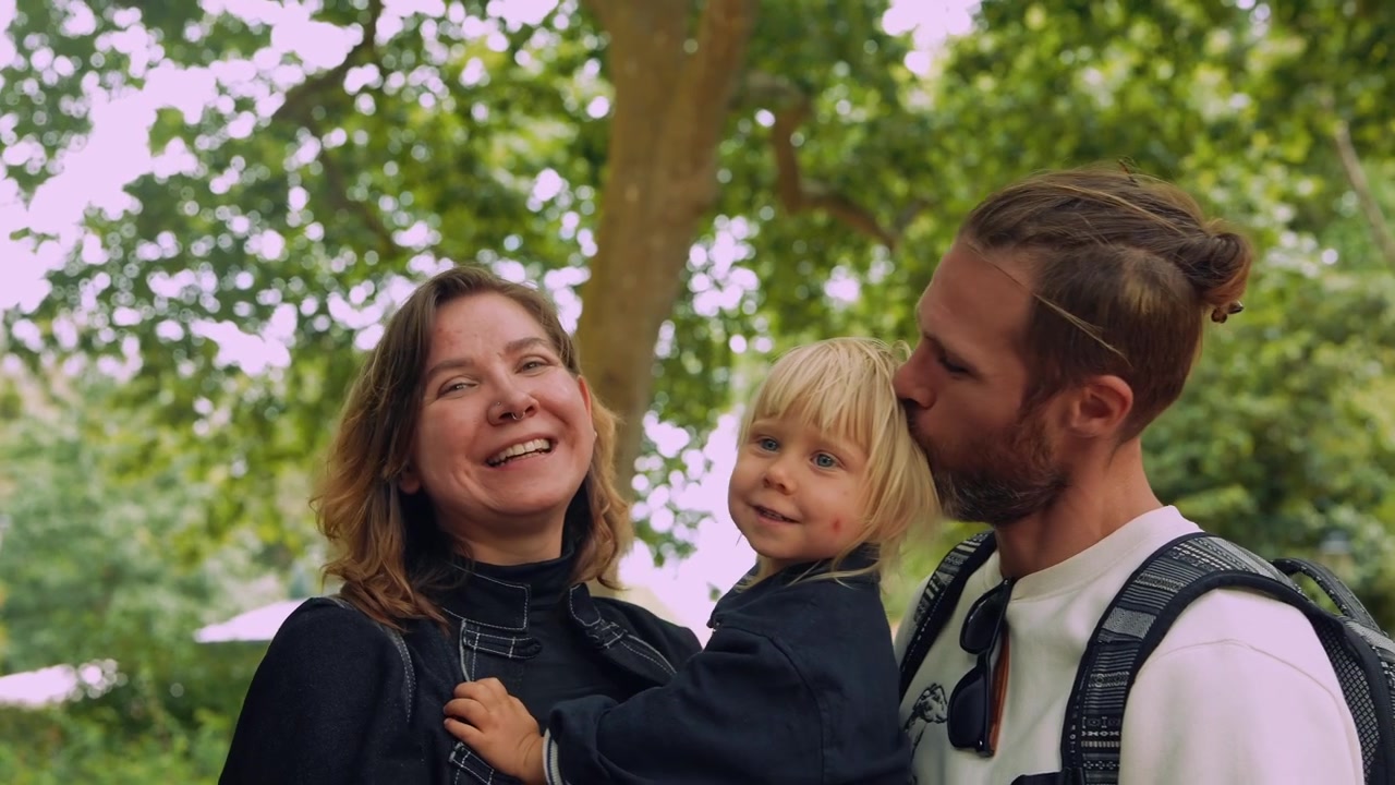 Famiglia felice con bambino piccolo che si scambia affetto in un parco
