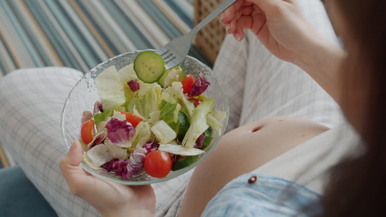 샐러드를 먹는 임신 한 여자