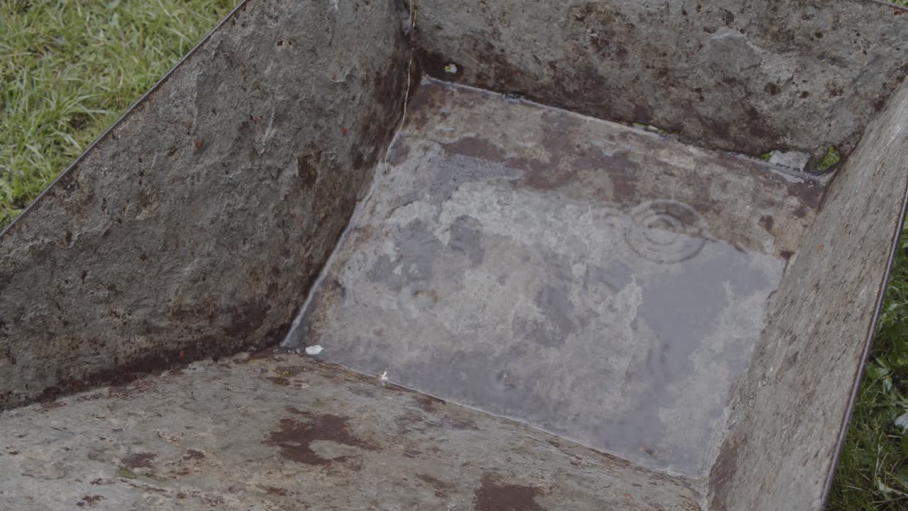 Gammel ståltrillebår i regnet, nærbilde 4K