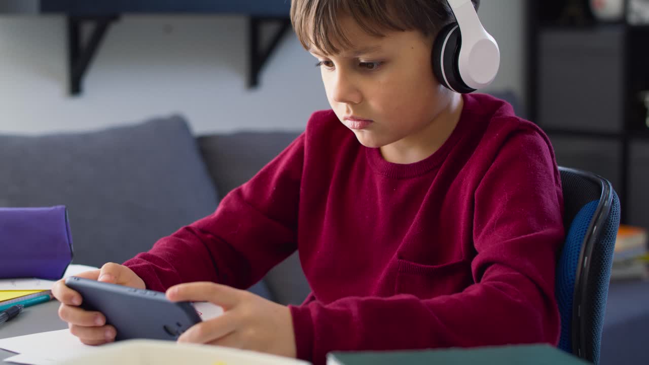 video de un niño jugando en el teléfono durante las clases en línea