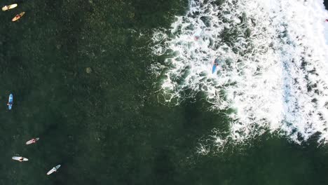 Antena-De-Arriba-Hacia-Abajo-De-Un-Surfista-Que-No-Logra-Atrapar-Una-Ola-En-La-Playa-De-Sayulita,-México