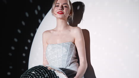 woman in a sparkly silver dress with a disco ball